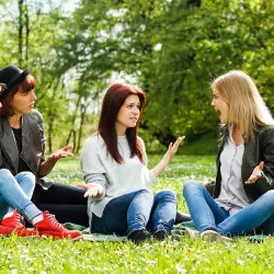 image of a woman in park on green grass arguing with friends