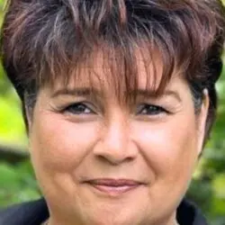 psychic ade with short curly brown hair and brown eyes.