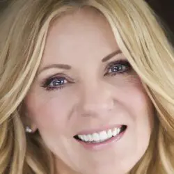 Psychic Shaye has blue/mauve eyes and blonde hair looking at the camera