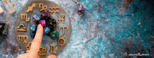 woman touching a zodiac wheel of star signs on a pale blue background