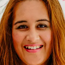 Portrait of Lara, a warm and approachable psychic reader with long auburn hair and a bright smile, offering empowering psychic readings that blend intuitive insight with practical guidance.