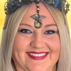 Close-up of Psychic Lee, a smiling Australian psychic medium wearing a decorative headpiece with crystals and a central pendant, symbolising her connection with spiritual guidance and psychic readings.