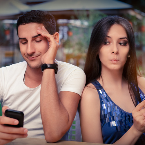 image of woman jealously looking over her partner's shoulders while he is on the phone