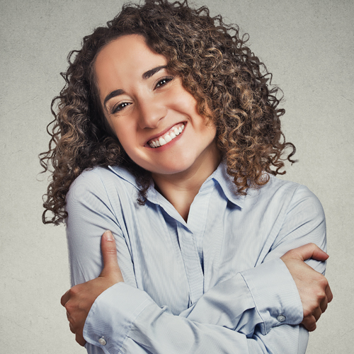 image of woman with curly hair hugging and loving herself