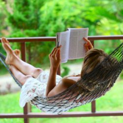 image of a relaxed woman reading a book on a hammock