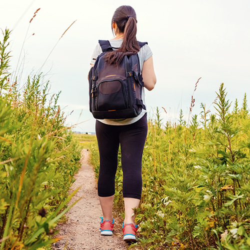 Woman wearing a backpack walking out in nature.