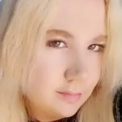 psychic Laura with blonde hair and brown eyes looking at the camera