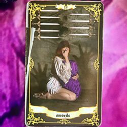 Woman weeping holding a purple blanket representing 9 of swords tarot card