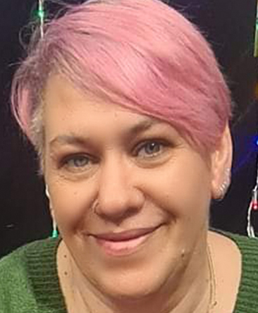 psychic tracey has short pink hair and soulful eyes.