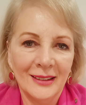 psychic marita has blonde hair and blue eyes wearing a pink scarf.