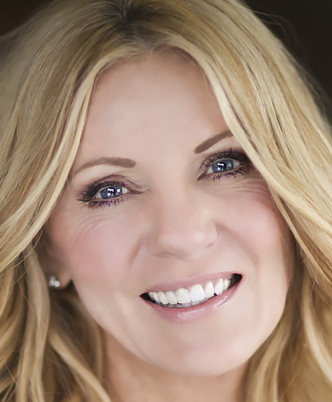 Psychic Shaye has blue/mauve eyes and blonde hair looking at the camera