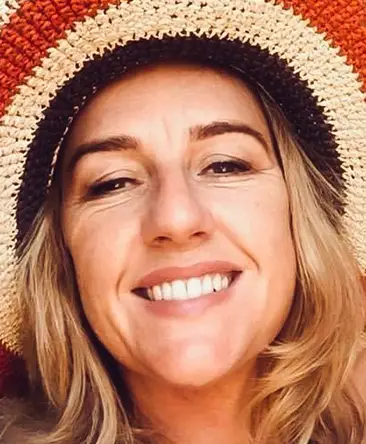 psychic edelle with wavy blonde hair and brown eyes wearing a straw hat