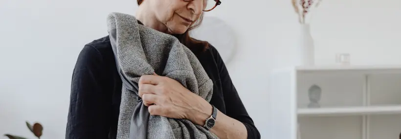 a woman missing someone, hugging a departed loved one's coat