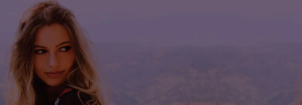 woman with long blonde hair looking backwards on dusty purple background