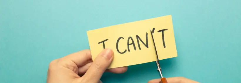 A creative photo illustration of a hand cutting the 'T' from I can't