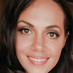 Portrait of Aimee, an intuitive psychic reader and tarot specialist, smiling warmly, with dark hair and natural makeup, offering compassionate phone psychic readings and spiritual guidance.